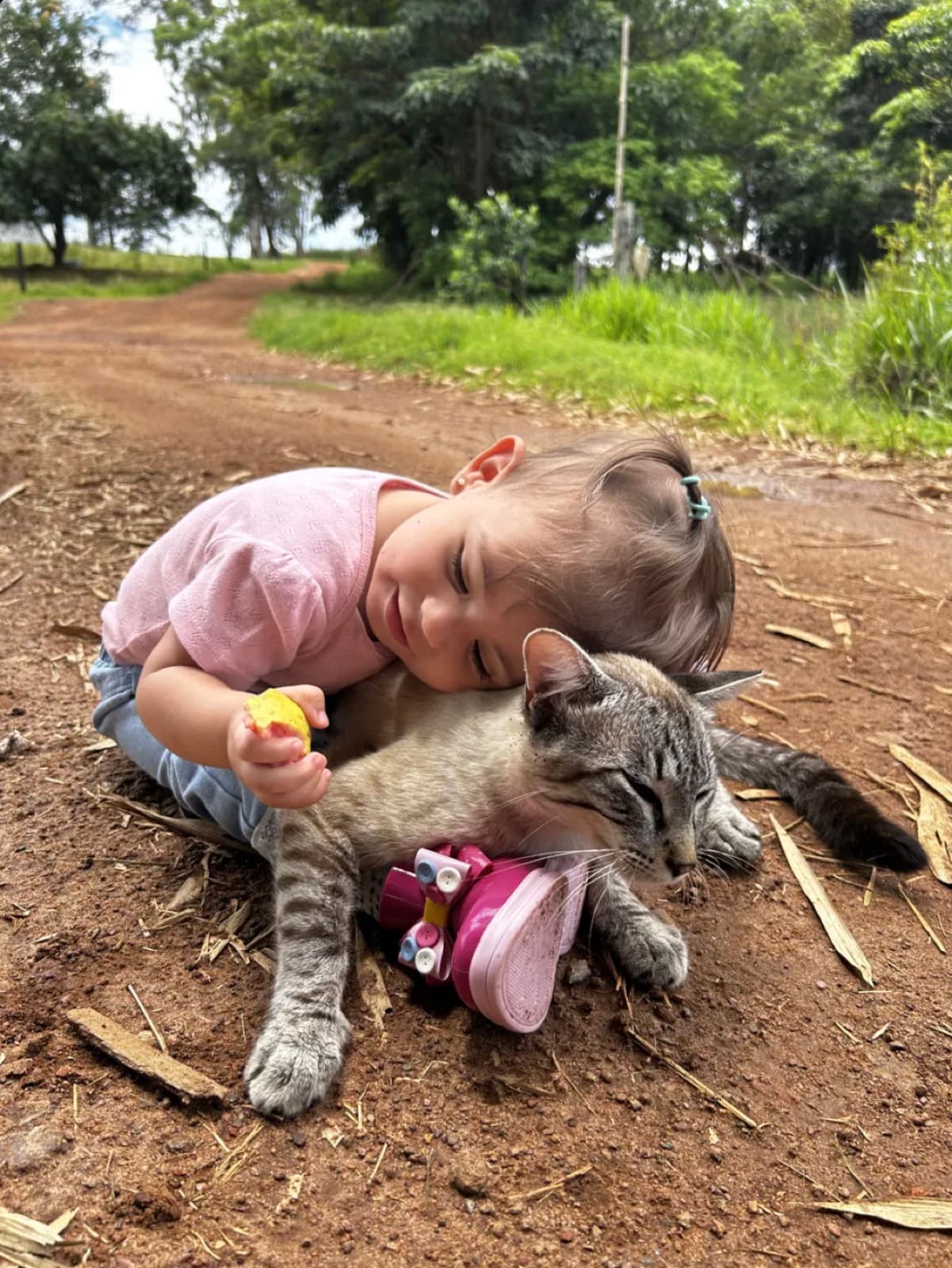 Lara deitada abraçando o gatinho